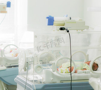儿童培育摄影照片_医院保温箱中的新生儿
