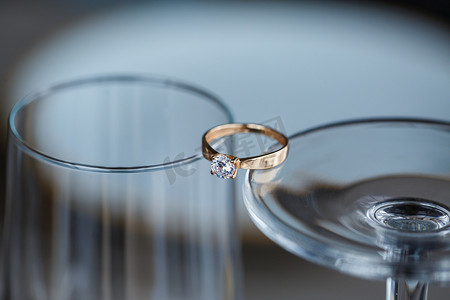 贵金属摄影照片_一枚由贵金属制成的镶有钻石的结婚戒指位于玻璃中