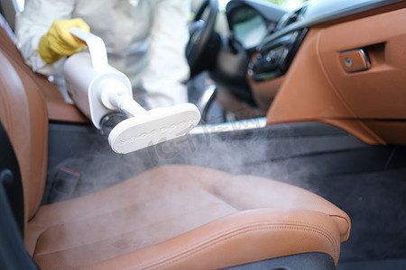 消毒摄影照片_用蒸汽清洗机对汽车内饰和汽车座椅进行蒸汽清洁和消毒