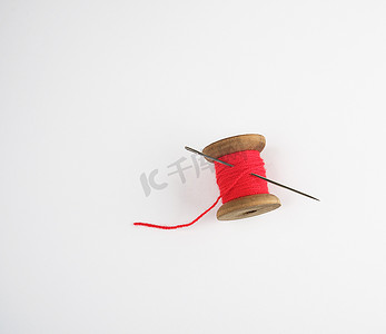红色卷轴摄影照片_有红色羊毛线和大针的木卷轴