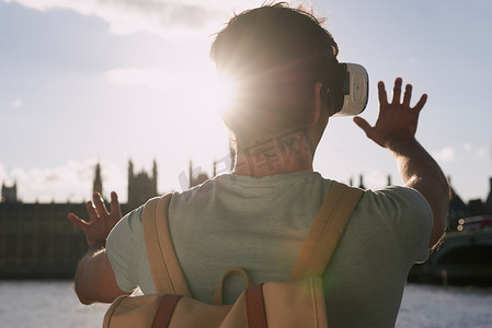 一名男子在探索伦敦市时使用虚拟现实耳机的后视镜头