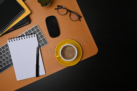 现代工作区的顶视图咖啡杯、笔记本和眼镜。