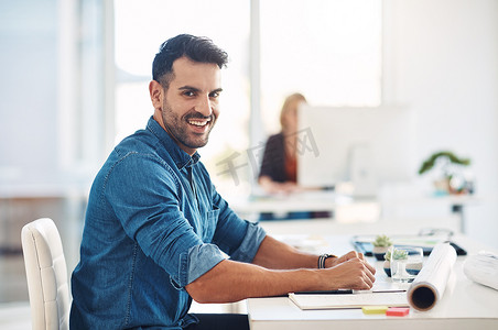 快乐的创意商人在办公桌前工作，在办公室工作时进行管理并记笔记。