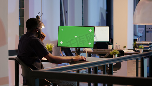 初创公司员工在大窗户的办公室显示器上分析绿屏