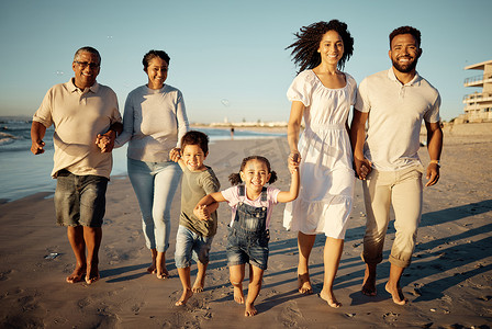 日落时分，幸福的家庭与小孩子一起在海滩上散步的肖像。