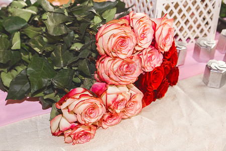 节日背景的桌子上放着一束红色和浅色的玫瑰花