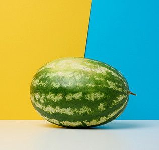 黄蓝色背景上的圆形条纹绿色西瓜。