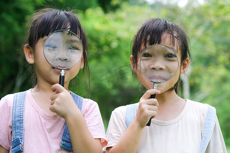 孩子们用户外放大镜学习和探索自然。
