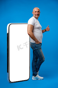 中年男子站着，展示带空白白屏的大型智能手机