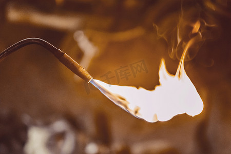 焊接火焰摄影照片_具有燃烧火焰的燃气燃烧器在工业车间的背景下关闭