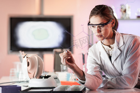 生命科学实验室一位自信的女研究员在玻璃板上书写结构化学公式的肖像。