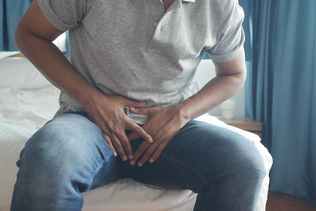 男人疼痛摄影照片_前列腺和膀胱问题的概念，年轻人的胯部疼痛