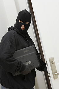 头戴巴拉克拉法帽的小偷从家里偷笔记本电脑