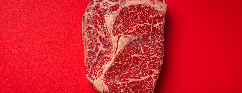 生肉牛肉优质切牛排肋眼从上面干净的红色背景，牛排概念横幅极简主义