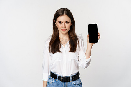 穿着公司服装的自信女性，展示智能手机屏幕、应用程序的移动界面，站在白色背景上