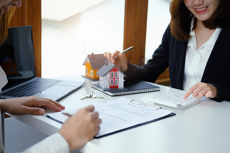 担保、抵押、合同、合同、签署、房地产经纪人或银行职员指着计算器，在签署交易前向客户提交出价购买房屋