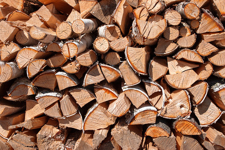 木头堆摄影照片_与堆木柴的农村抽象背景。切碎的木头堆积在堆中。
