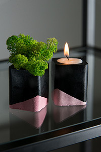 黑色和粉色混凝土烛台中的蜡烛和苔藓