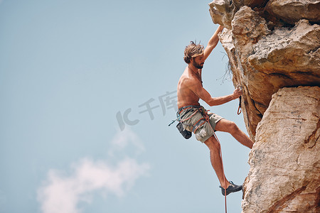 极限攀岩摄影照片_男子登山或攀岩，而悬崖悬挂和肾上腺素运动员冒险并检查安全设备、钩子和绳索。