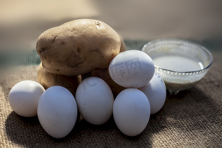 土豆和蛋清面膜，用生土豆和鸡蛋以及在玻璃碗中制成的面膜，在棕色表面上实现自然发光的皮肤。
