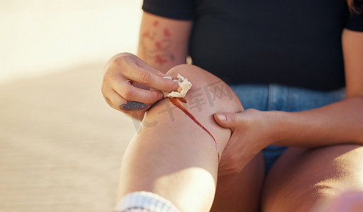 促进摄影照片_膝盖受伤和人用组织清洁血伤口以止血以促进愈合和康复。