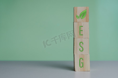 能量社交摄影照片_绿色背景和复制空间上带有 esg 符号环境社会治理的木制立方体。