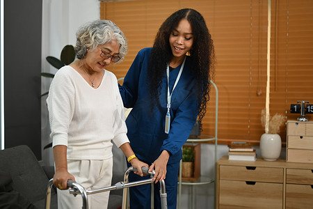 有爱心的护士参加，帮助老年妇女在家里行走框架助行器。
