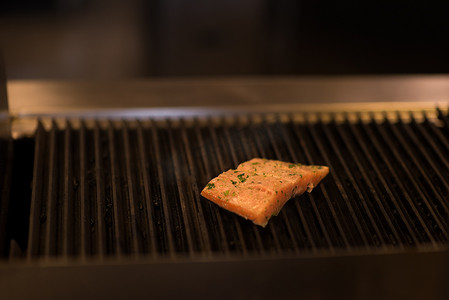 火焰牛排摄影照片_在烤架上烹饪的三文鱼片