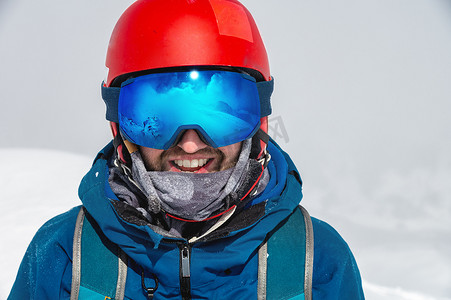 关闭一个男人的滑雪护目镜与雪山的反射。