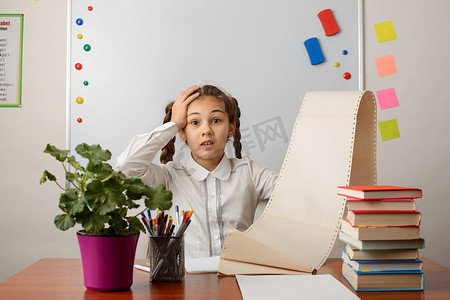 清单表摄影照片_震惊的小学生女孩的照片，她有大量的待办事项