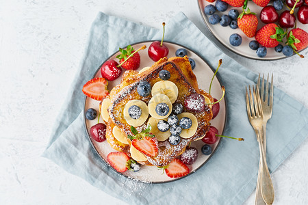 法式烤面包配浆果、奶油蛋卷早餐、白色背景顶视图