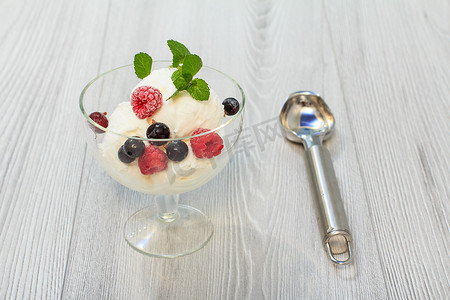 玻璃杯中的白色冰淇淋，配覆盆子和醋栗浆果