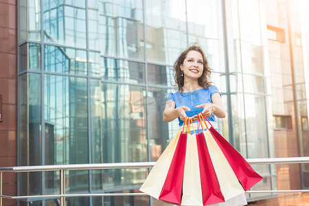 购买、折扣和人的概念 — 年轻女性穿着彩色购物袋走路的肖像