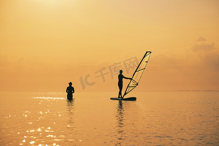 海上日落，SUP 板上划桨女孩的剪影