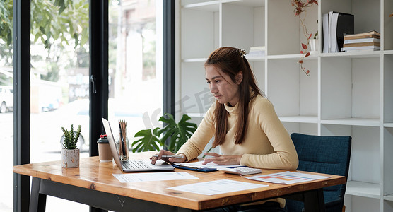 在办公室工作的快乐亚洲女性使用带复印空间的电脑。