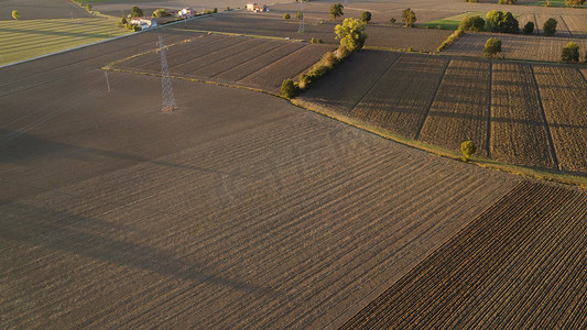 农民耕种摄影照片_意大利皮亚琴察 — 9 月 22 日日落时农民驾驶拖拉机深耕土地