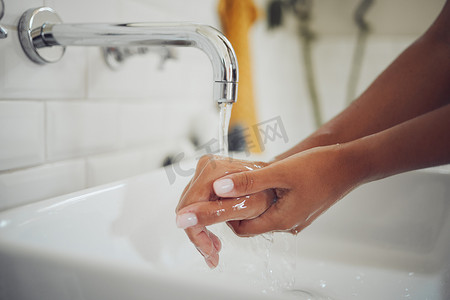 上洗手摄影照片_一名妇女在浴室水槽上用水洗手、没有肥皂的特写。 