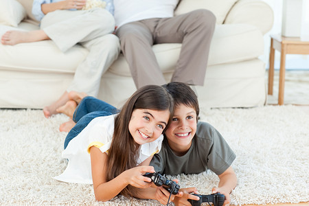 孩子们在父母聊天时玩电子游戏