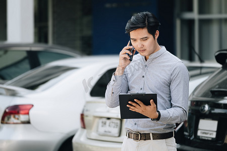 保险索赔概念，汽车保险保单持有人与持有保险文件的汽车保险公司通电话，通知汽车维修。