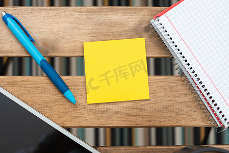 粘滞便笺上的重要信息与笔、电话屏幕和笔记本放在桌子上。