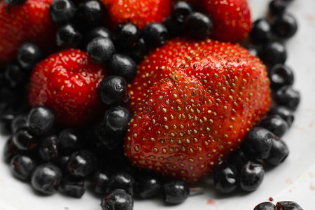 许多多汁的新鲜成熟红草莓浆果与黑莓隔离在白色背景