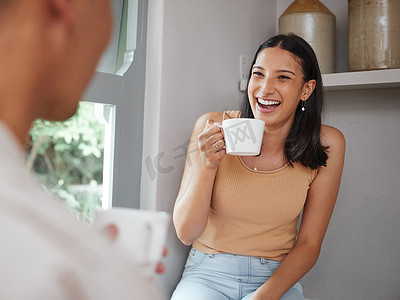 开心大笑的女人摄影照片_快乐、无忧无虑、欢笑的女人早上喝咖啡，在家里和男朋友玩得很开心。