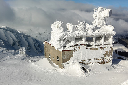 斯洛伐克亚斯纳 — 2018年1月18日：乔波克山顶的滑雪缆车大楼，屋顶上有天线，完全被雪覆盖。