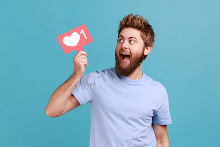 齿形边框摄影照片_身穿 T 恤的男子举着类似柜台的标志，要求对他在社交媒体上的内容做出更多反应。