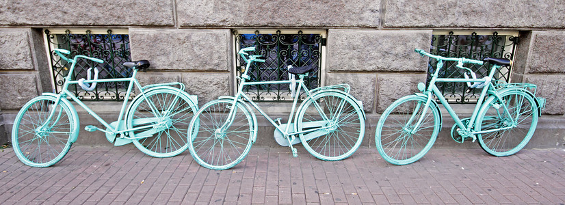荷兰阿姆斯特丹靠墙的三辆绿色自行车