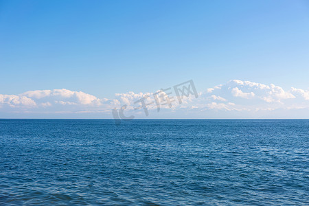 大海云朵背景摄影照片_蓝色平静的大海和白色的云朵。