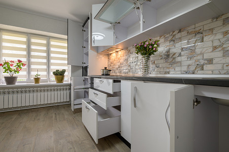 现代时尚白色厨房的内饰经过翻新，门打开