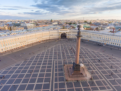 喀赞摄影照片_日落时宫殿广场和亚历山大柱的鸟瞰图，背景是喀山斯基大教堂的圆顶，冬宫，散步的小人