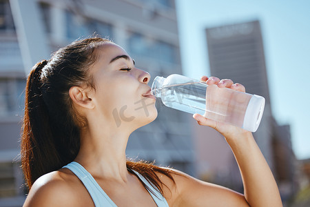 在户外夏季有氧运动训练中放松、健身和喝水的女孩。