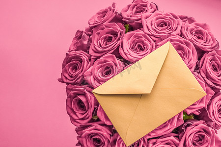 信封书信摄影照片_节日情书和鲜花递送、豪华玫瑰花束和腮红粉红色背景的卡片，适合浪漫的节日设计